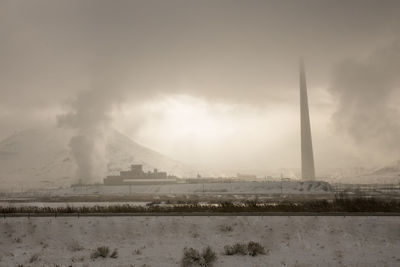 Smoke emitting from chimney against sky