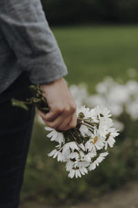 Midsection of woman holding flowers