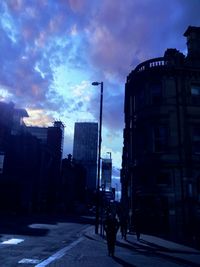 Buildings in city against cloudy sky