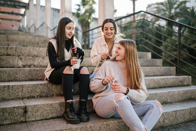 Happy friends sitting on staircase