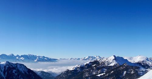 Scenic view of snowcapped mountains against clear blue sky