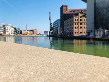 River by buildings in city against sky