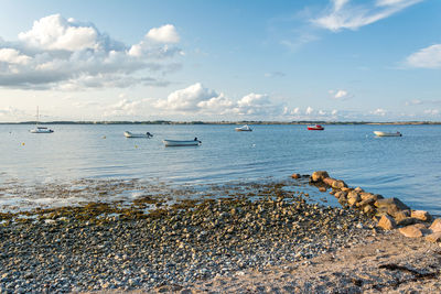 Sailboats in sea against sky