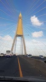 Cars on road against sky in city