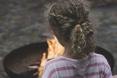 Rear view of girl in front of fire