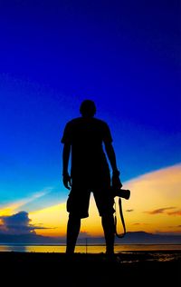 Silhouette man standing against blue sky during sunset