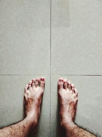 Low section of woman standing on tiled floor