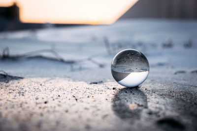 Close-up of crystal ball on beach