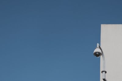 Low angle view of security camera against clear sky