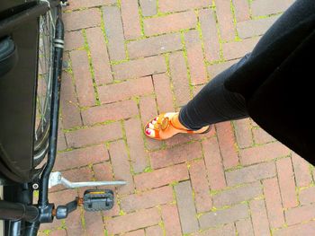 Low section of woman standing on sidewalk