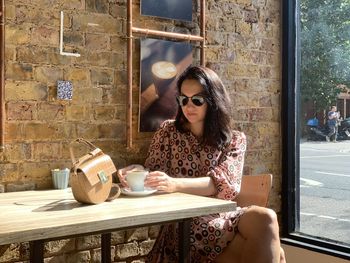 Young woman using mobile phone while sitting at home