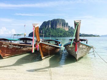 Boat moored on beach against sky