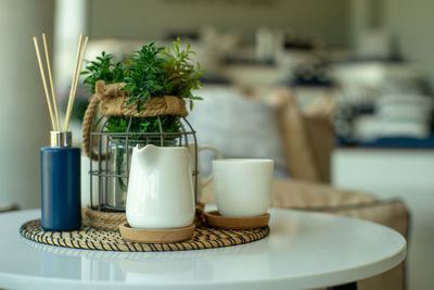 Closeup set of white ceramic cup and jug of tea and coffee with bokeh background.