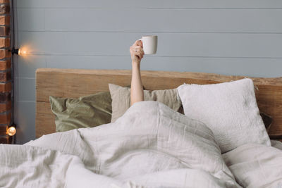 Low section of man relaxing on bed at home