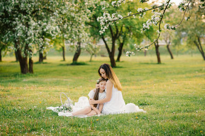 A happy young woman sits on a picnic blanket