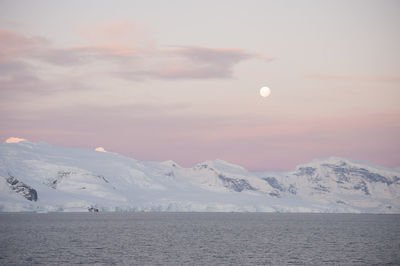 Scenic view of snowcapped mountains against sky during sunset