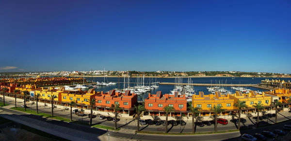 A panoramic view to rental houses and a harbor with anchored boats at praia da rocha