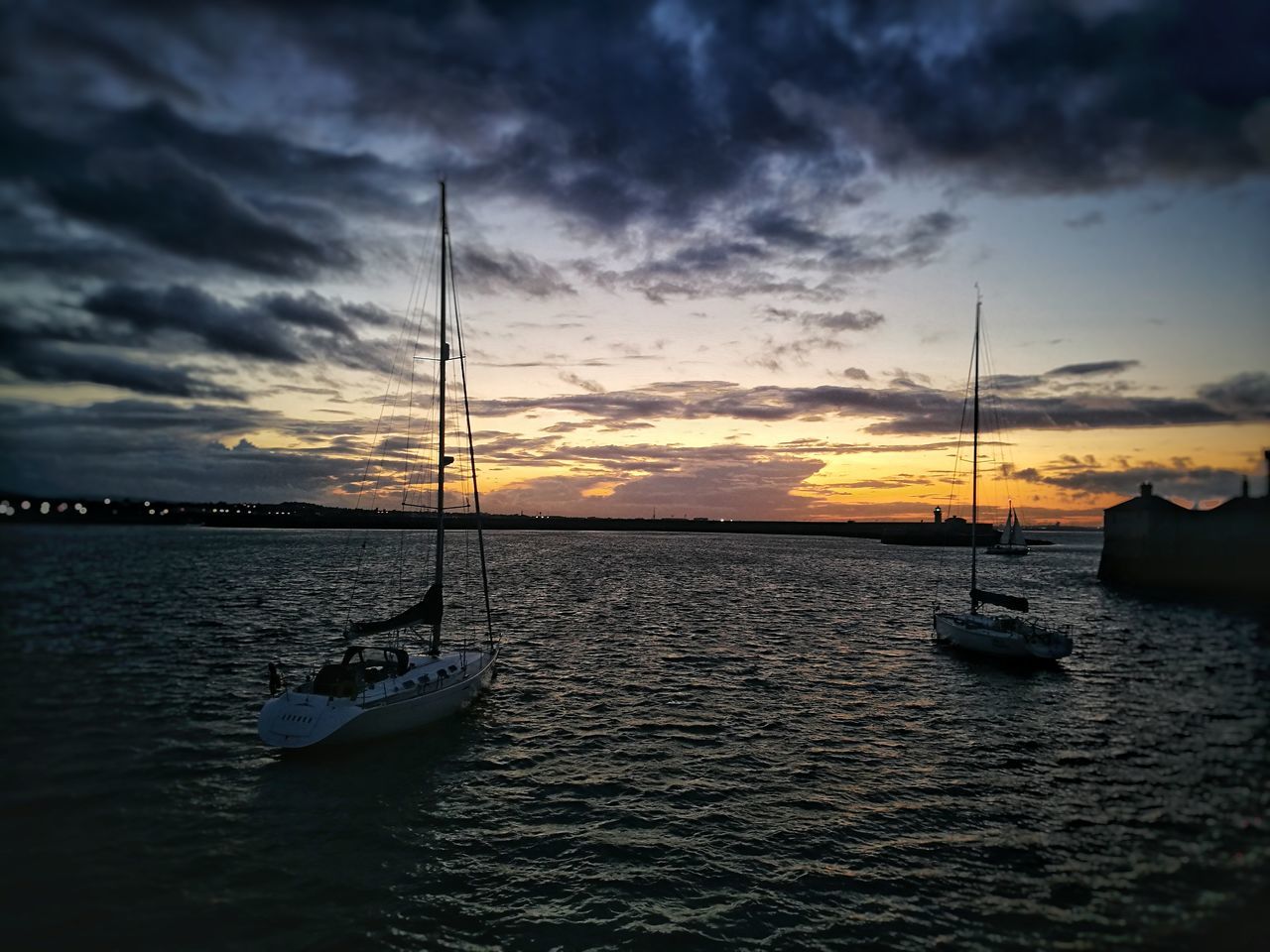 BOAT MOORED ON SEA AGAINST SKY