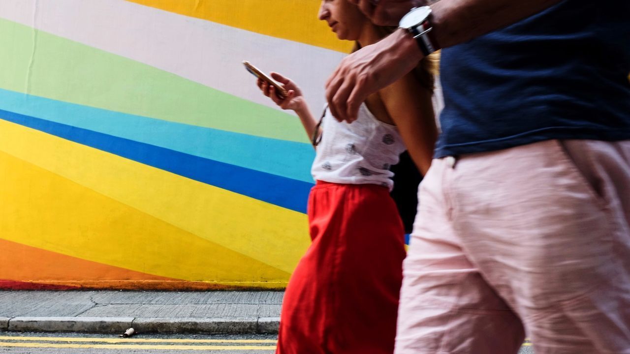 LOW SECTION OF PERSON STANDING ON MULTI COLORED UMBRELLA