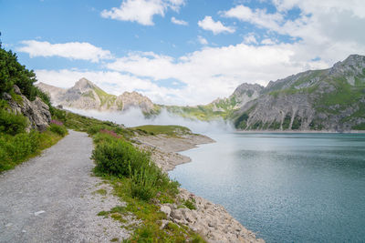 Scenic view of lake by mountains against sky