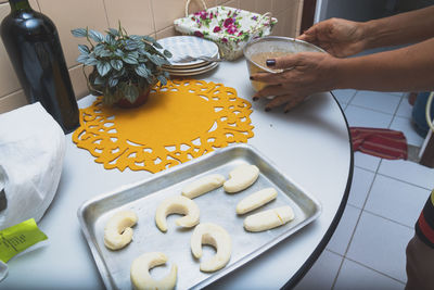 Cropped hand of woman holding cookies on table