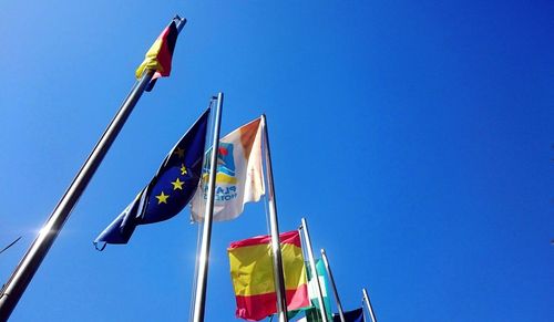 Low angle view of flags against clear sky