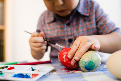 Midsection of boy holding ice cream on table