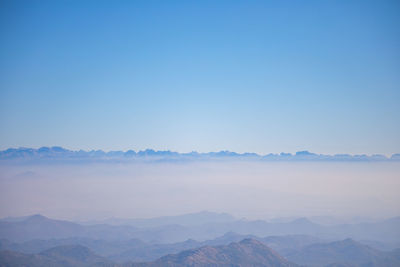 Scenic view of mountains against clear blue sky