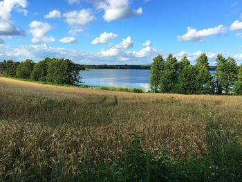 Scenic view of calm lake against cloudy sky