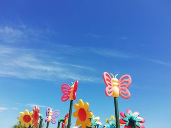 Low angle view of multi colored roses against blue sky