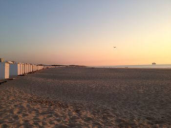 Scenic view of beach against clear sky during sunset