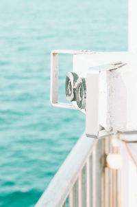 Close-up of metal railing against sea