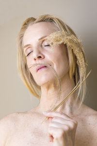 Blonde woman with dry branch in hand