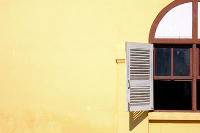 Close-up of yellow window on wall of building