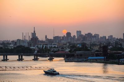 View of city at waterfront during sunset