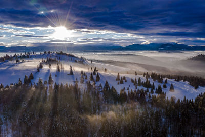 Panoramic view of snowcapped landscape against sky during winter