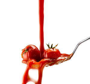 Close-up of red chili peppers against white background