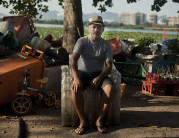 Full length portrait of young man sitting outdoors