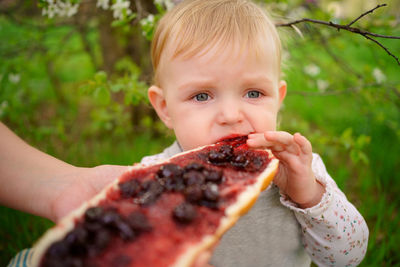 Mother and daughter eat jam bread at a picnic spring