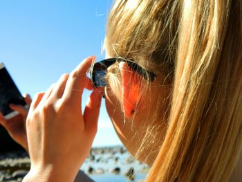 Close-up of cropped woman holding camera