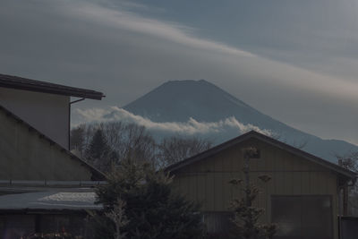 House and buildings against sky during winter
