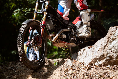 Low section of person riding motorcycle on field