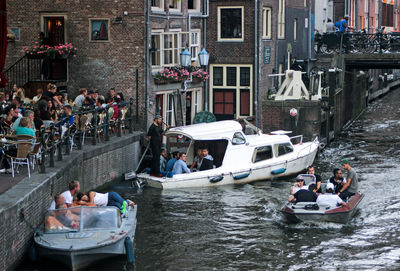 People on boats in canal along buildings