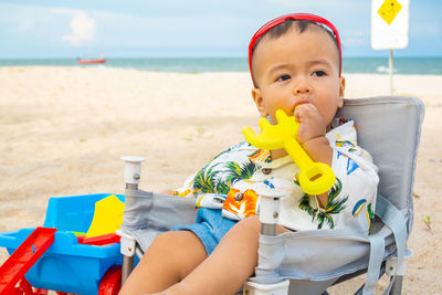 Portrait of baby boy sitting on beach