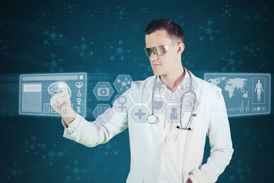 Digital composite image of doctor touching icons against colored background