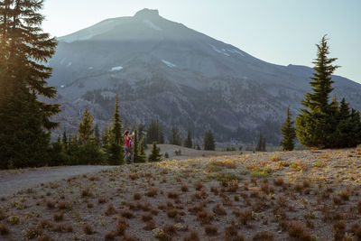 Young woman far away on trail near mountain