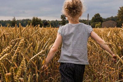 Rear view of boy standing on field