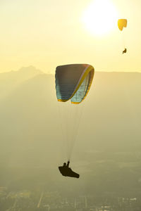 Paragliders silhouetted flying at sunset