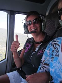 Portrait of smiling mature woman showing thumbs up in helicopter