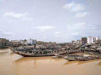 Boats moored in city against sky